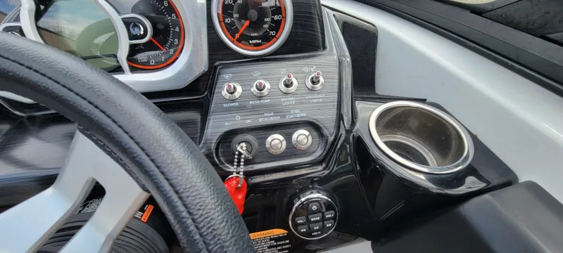 Slide: The Image of Dashboard of 2021 Scarab 215 ID boat with gauges, switches, and cup holder. - 17