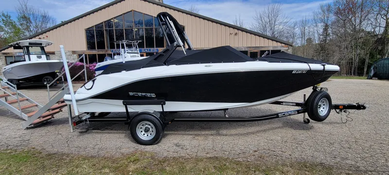 Slide: The Image of 2021 Scarab 215 ID boat on trailer, black and white, parked outdoors near a building. - 3