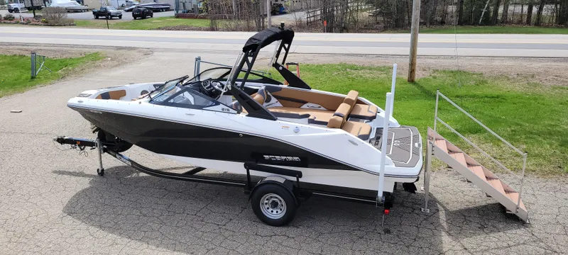 Slide: The Image of 2021 Scarab 215 ID boat on trailer, black and white design, outdoor setting. - 5