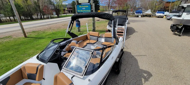 Slide: The Image of 2021 Scarab 215 ID boat with tan seating, parked outdoors on a sunny day. - 7