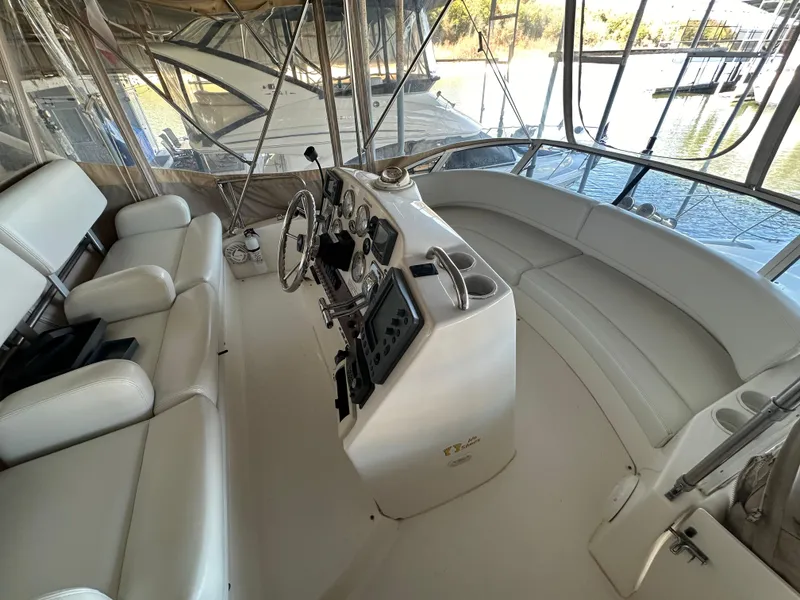Slide: The Image of 2002 Silverton 35 Convertible yacht interior with helm and seating area. - 13