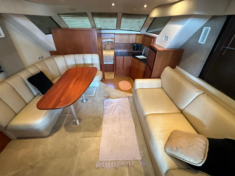 Slide: The Image of Interior of 2002 Silverton 35 Convertible yacht with leather seating and wooden table. - 15