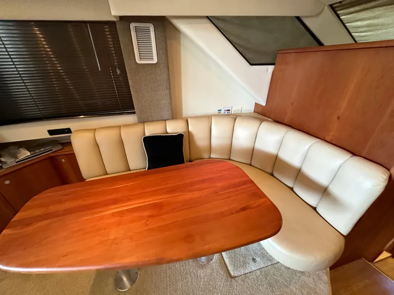 Slide: The Image of Interior of 2002 Silverton 35 Convertible yacht with plush seating and wooden table. - 19