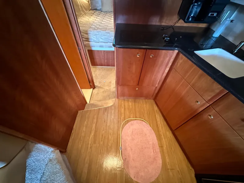 Slide: The Image of Interior of 2002 Silverton 35 Convertible yacht with wood flooring and compact kitchen. - 23