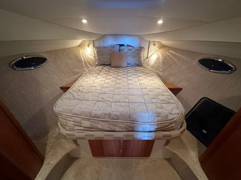 Slide: The Image of Cozy bedroom in 2002 Silverton 35 Convertible yacht with elegant lighting and plush bedding. - 24