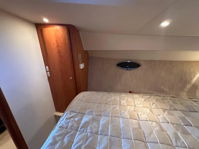 Slide: The Image of Interior cabin of 2002 Silverton 35 Convertible yacht with bed and wooden door. - 28