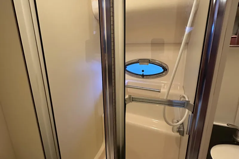 Slide: The Image of Shower area in 2002 Silverton 35 Convertible boat with oval window and sliding door. - 32