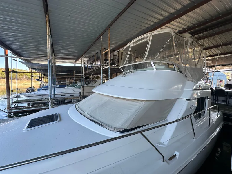 Slide: The Image of 2002 Silverton 35 Convertible yacht docked under a covered marina. - 4