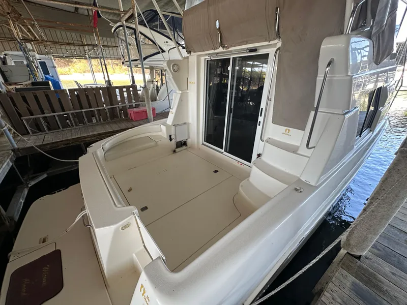 Slide: The Image of 2002 Silverton 35 Convertible boat docked in a marina, rear view. - 5
