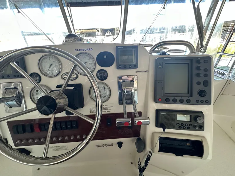Slide: The Image of Control panel of a 2002 Silverton 35 Convertible boat with steering wheel and navigation instruments. - 9