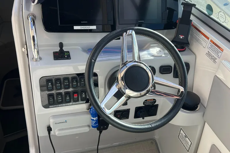Slide: The Image of 2021 Regal 28 Express boat dashboard with steering wheel and control panel. - 12