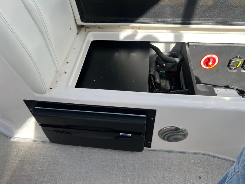 Slide: The Image of Regal 28 Express 2021 boat storage compartment with open hatch and visible equipment. - 15