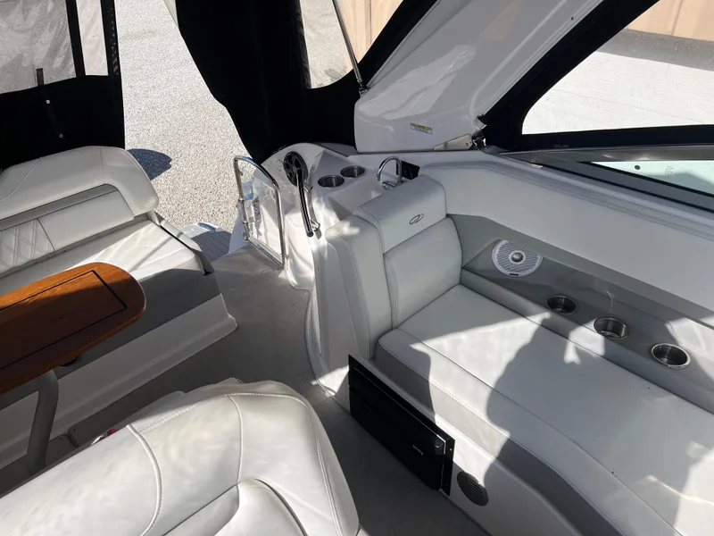 Slide: The Image of 2021 Regal 28 Express boat interior with white seating and wooden table. - 16