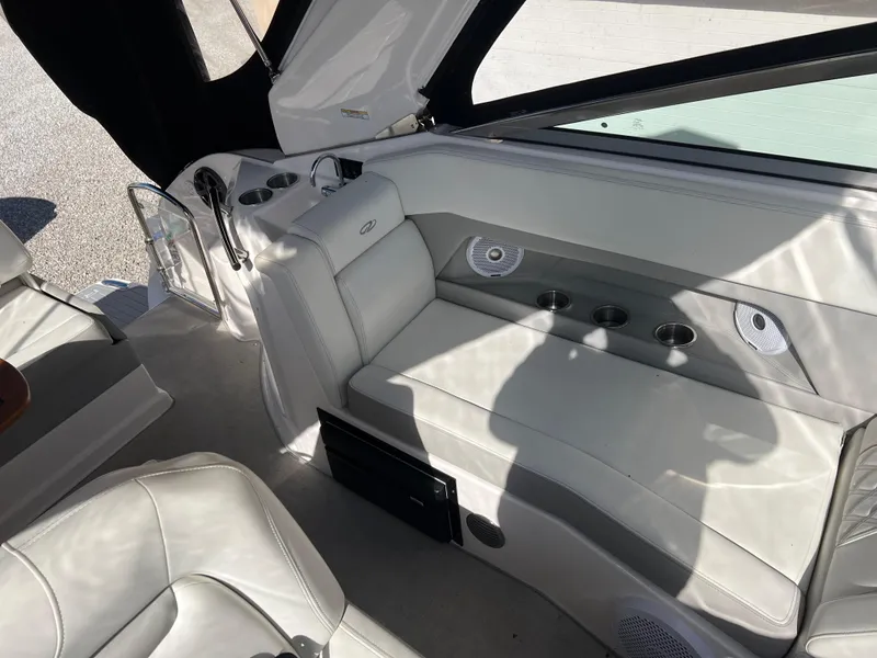 Slide: The Image of 2021 Regal 28 Express boat interior with white leather seating and cup holders. - 21