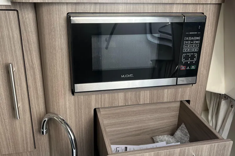 Slide: The Image of Microwave in 2021 Regal 28 Express boat kitchen with wood cabinetry. - 25
