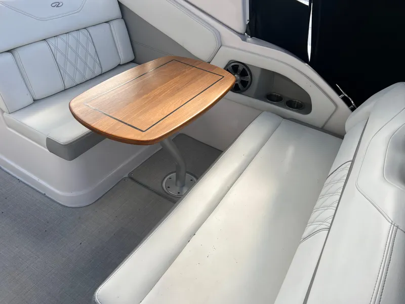 Slide: The Image of 2021 Regal 28 Express boat interior with wooden table and white seating. - 27