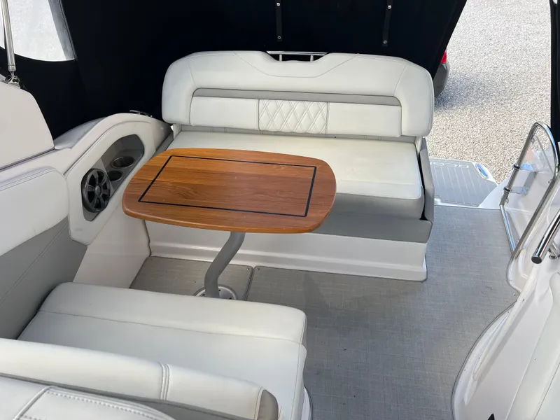 Slide: The Image of 2021 Regal 28 Express boat interior with white seating and wooden table. - 28