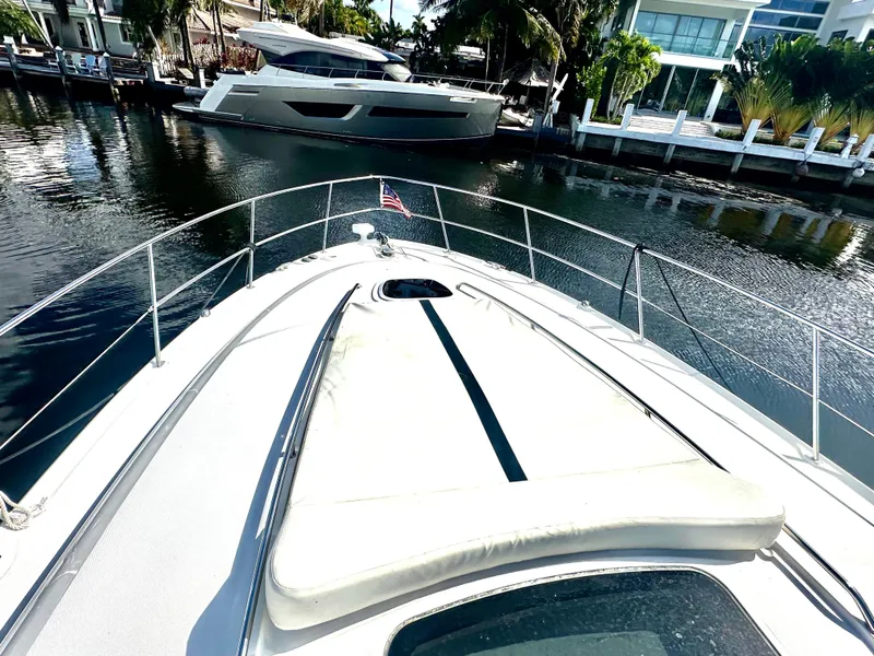 Slide: The Image of 2005 Sea Ray 420 Sundancer yacht docked in a serene marina setting. - 11