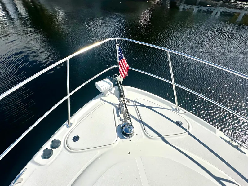 Slide: The Image of 2005 Sea Ray 420 Sundancer bow with American flag on calm water. - 12