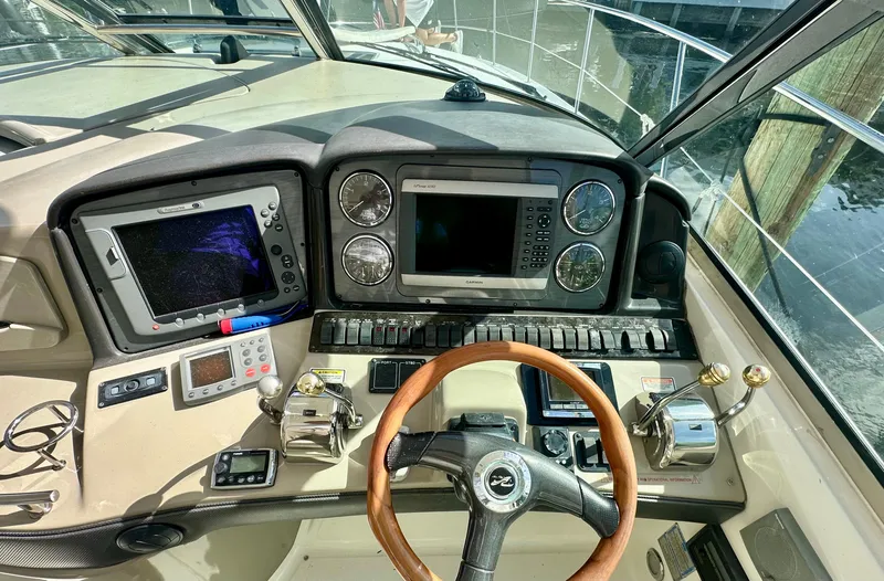 Slide: The Image of 2005 Sea Ray 420 Sundancer helm with navigation controls and steering wheel. - 14