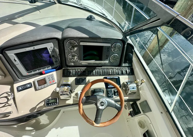 Slide: The Image of 2005 Sea Ray 420 Sundancer helm with navigation instruments and wooden steering wheel. - 15