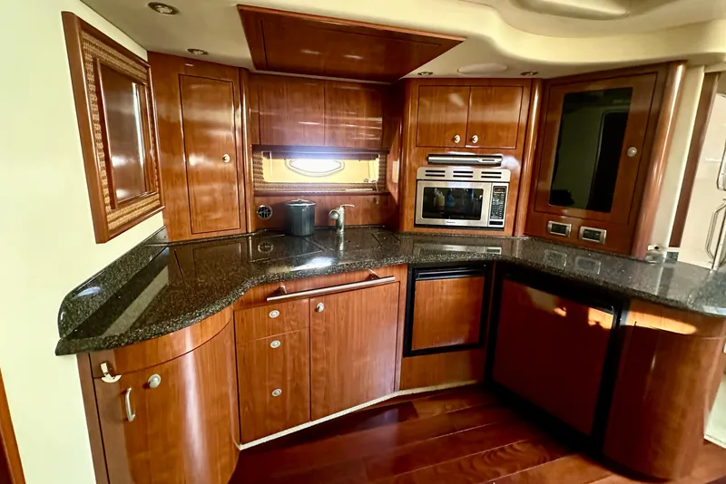 Slide: The Image of Luxurious 2005 Sea Ray 420 Sundancer yacht kitchen with wood cabinetry and modern appliances. - 36