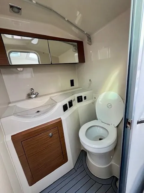 Slide: The Image of 2016 Cruisers Sport Series 328CX boat bathroom with sink, mirror, and toilet. - 12