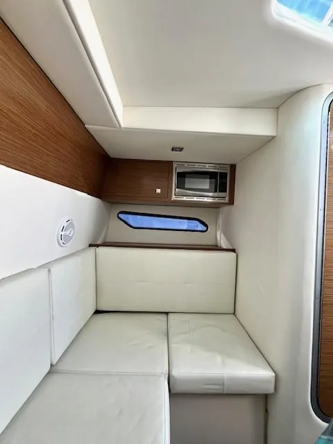 Slide: The Image of Interior of 2016 Cruisers Sport Series 328CX, featuring white seating and wood accents. - 14