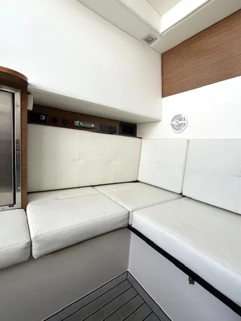 Slide: The Image of 2016 Cruisers Sport Series 328CX interior with white cushioned seating and wood accents. - 15