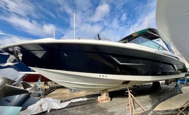 Slide: The Image of 2016 Cruisers Sport Series 328CX boat on dry dock under blue sky. - 2