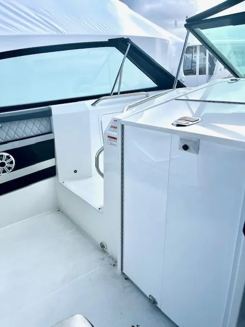 Slide: The Image of 2016 Cruisers Sport Series 328CX boat interior with sleek white design and seating. - 23