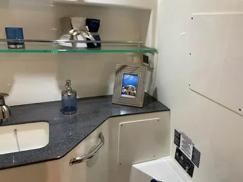 Slide: The Image of Interior of 2023 Boston Whaler 325 Conquest, featuring a modern bathroom with sleek countertop. - 26