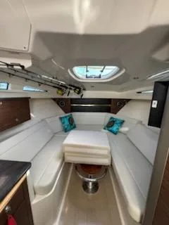 Slide: The Image of 2023 Boston Whaler 325 Conquest cabin interior with white seating and skylight. - 40