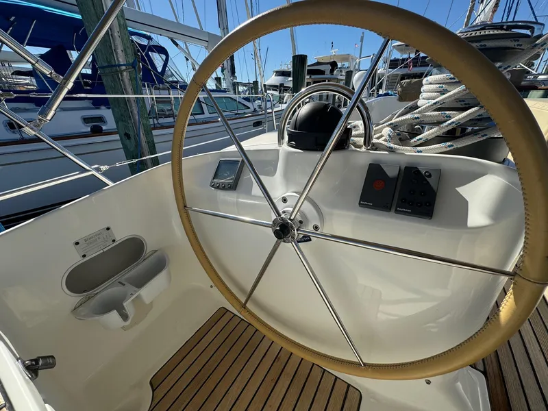 Slide: The Image of Steering wheel of 2002 Beneteau 50 yacht with navigation instruments and wooden deck. - 15