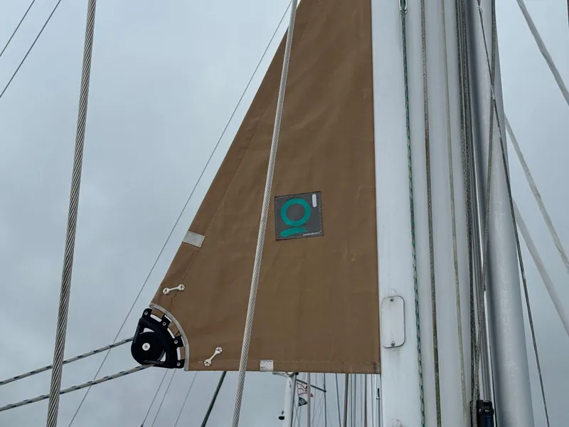 Slide: The Image of Close-up of a 2002 Beneteau 50 sailboat mast and sail against a cloudy sky. - 18