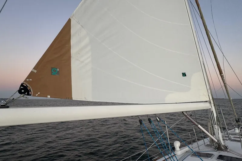 Slide: The Image of Sailing on a 2002 Beneteau 50 yacht with white sails at sunset. - 19