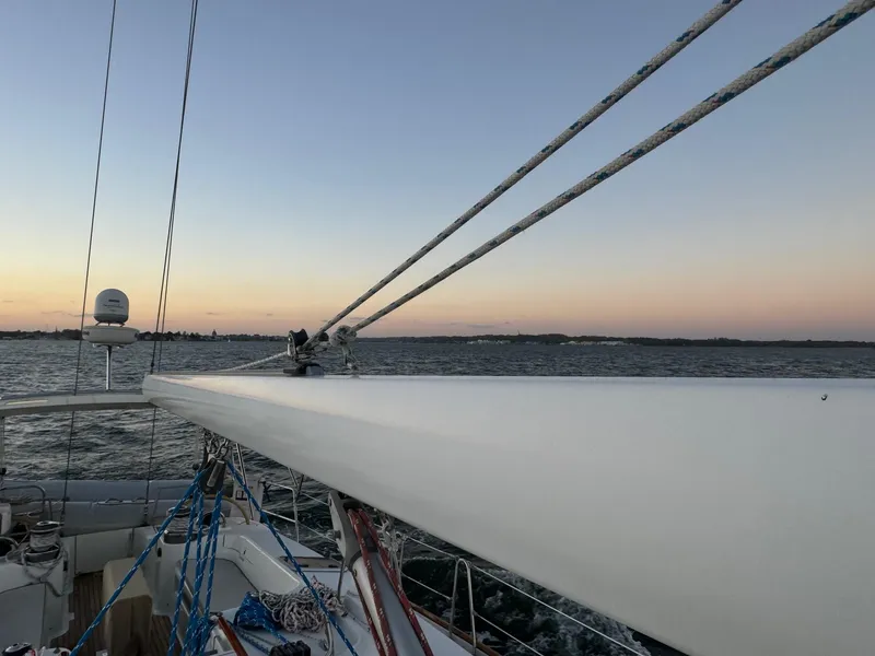 Slide: The Image of Sailing on a 2002 Beneteau 50 yacht at sunset, calm waters in the background. - 21