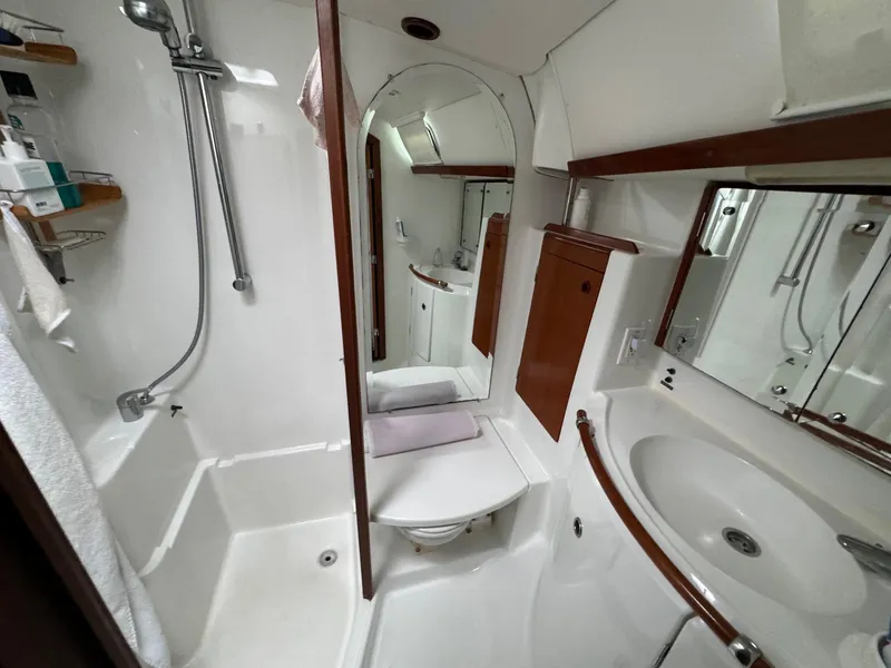 Slide: The Image of Beneteau 50 yacht bathroom, 2002 model, featuring shower, sink, and mirror. - 23