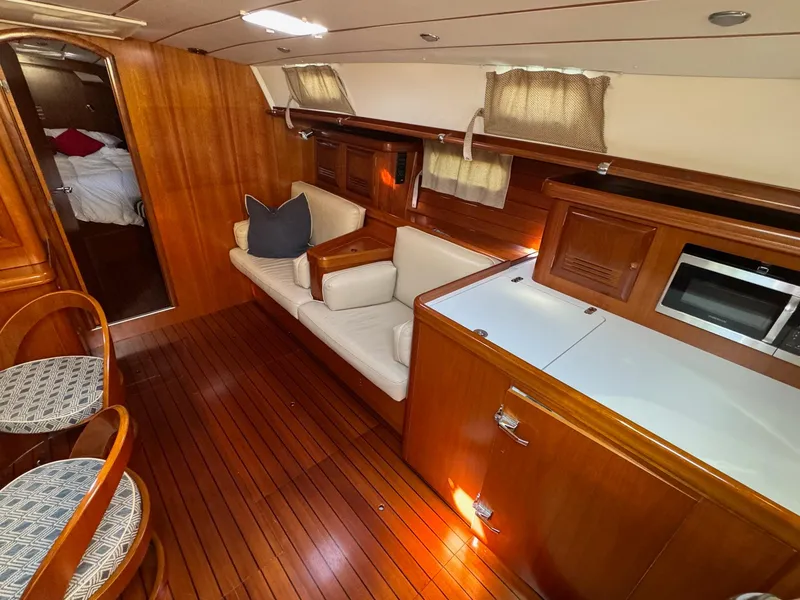 Slide: The Image of Interior of 2002 Beneteau 50 yacht with wooden flooring and cozy seating area. - 29
