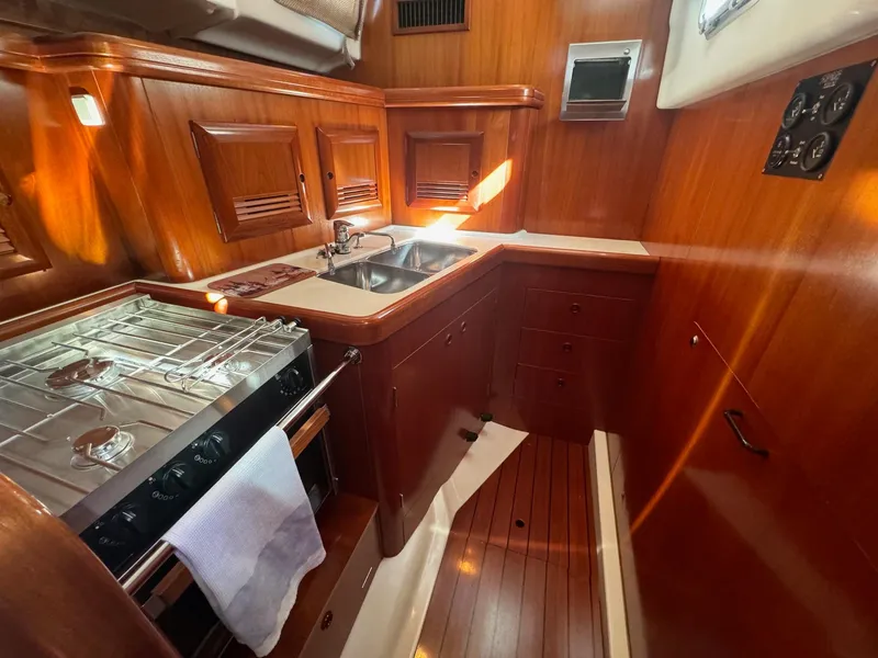 Slide: The Image of Luxurious wooden kitchen interior of 2002 Beneteau 50 yacht with stove and sink. - 3