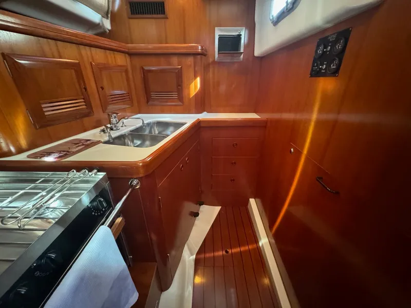 Slide: The Image of Interior of 2002 Beneteau 50 yacht kitchen with wood finish and stainless steel sink. - 34