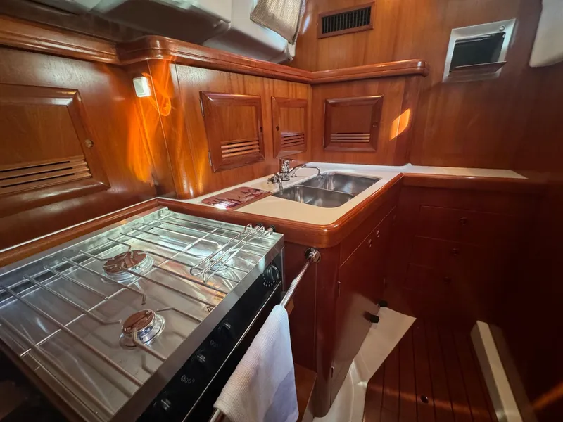 Slide: The Image of Luxurious 2002 Beneteau 50 yacht kitchen with wood cabinetry and stainless steel appliances. - 35
