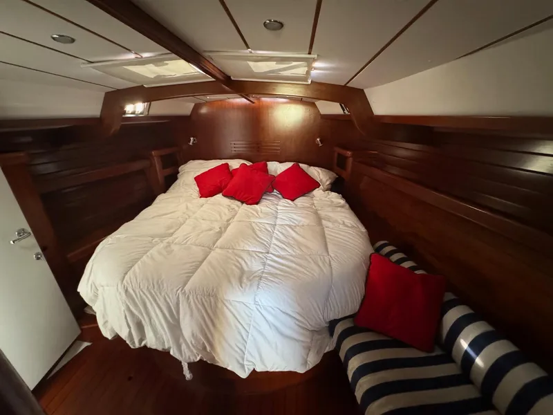 Slide: The Image of Luxurious cabin interior of 2002 Beneteau 50 yacht with cozy bedding and red accents. - 37