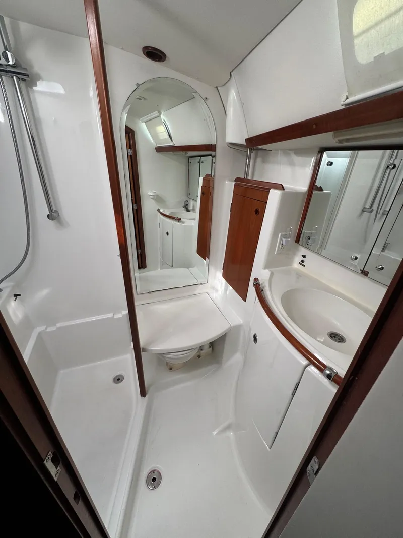 Slide: The Image of Beneteau 50 yacht bathroom, 2002 model, featuring shower, sink, and mirror. - 39