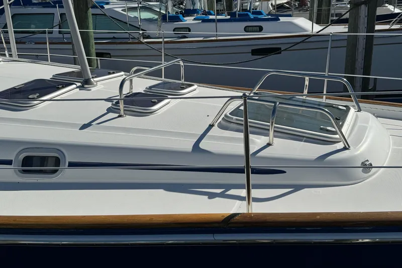 Slide: The Image of 2002 Beneteau 50 sailboat deck with hatches and railing in marina. - 6