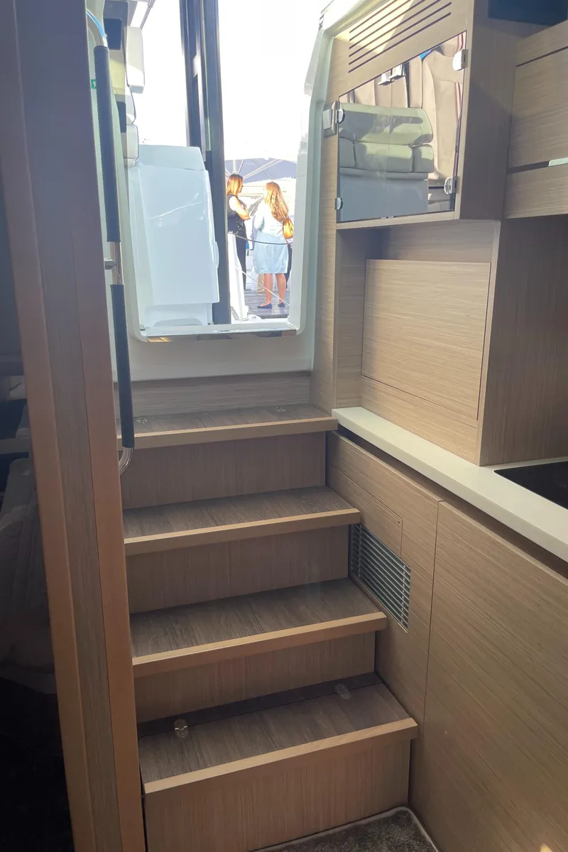 Slide: The Image of Interior stairs of 2025 Jeanneau Leader 12.5 WA yacht, featuring modern wood finish. - 18