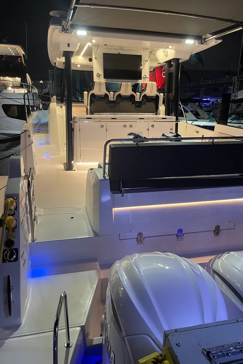 Slide: The Image of 2025 Jeanneau Leader 12.5 WA boat with illuminated deck at night. - 27