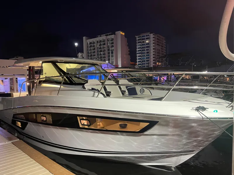 The Image of 2025 Jeanneau Leader 12.5 WA yacht docked at night, city skyline in background. - 0