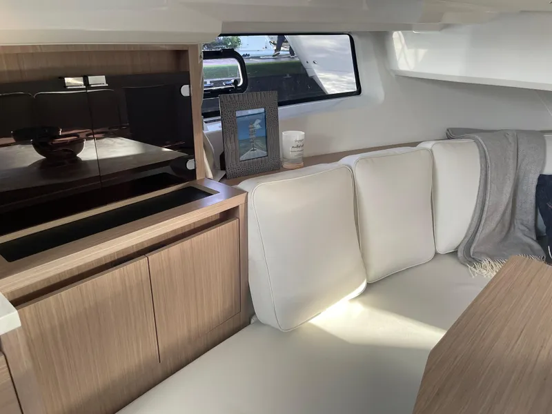 Slide: The Image of Interior of 2025 Jeanneau Leader 12.5 WA with white seating and wood cabinetry. - 10