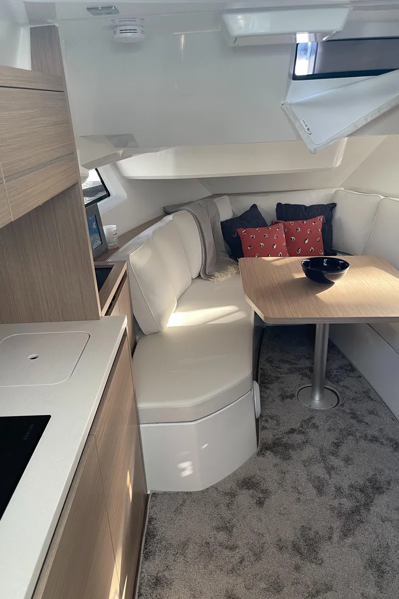 Slide: The Image of 2025 Jeanneau Leader 12.5 WA cabin interior with modern seating and dining area. - 16